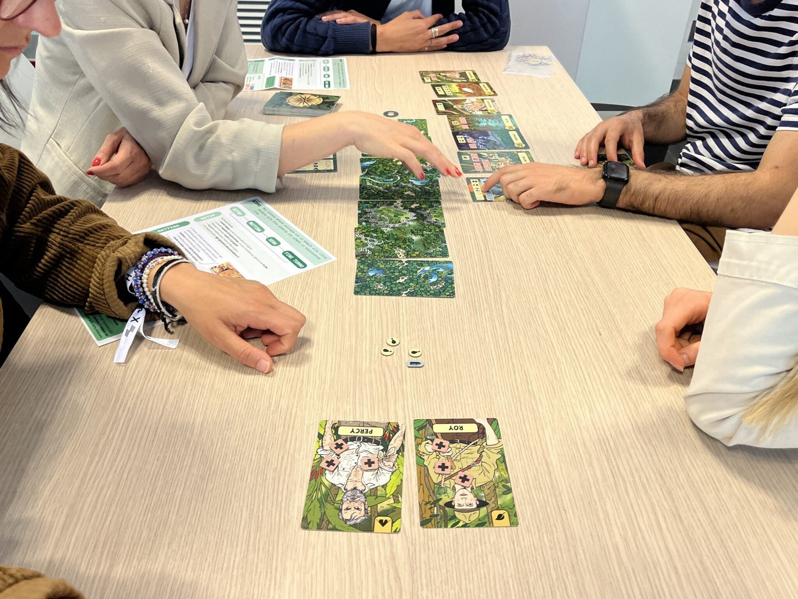 Mani al lavoro su mappe e materiali durante un workshop del progetto HSE del futuro